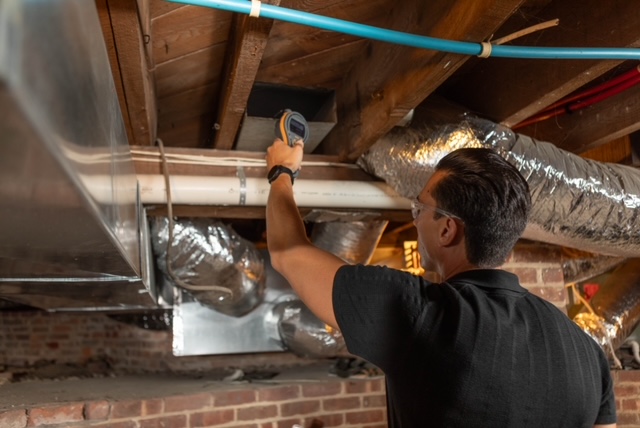Technician inspecting ductwork for the source of a lingering odor